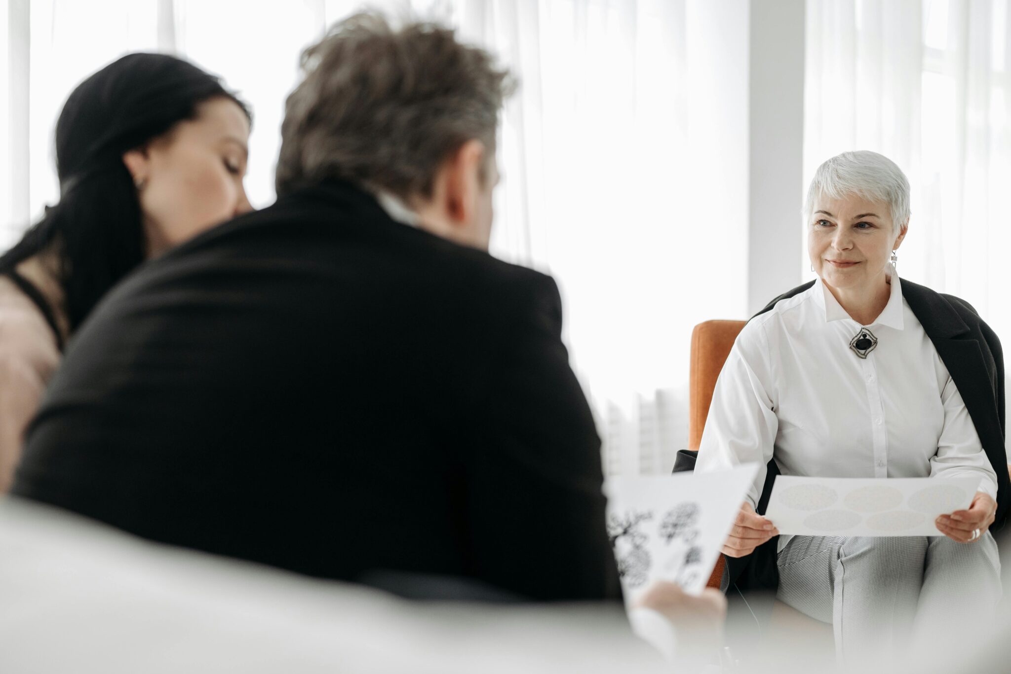 Groupe discutant avec documents en réunion professionnelle.